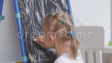 小女孩在画板上画白色粉笔